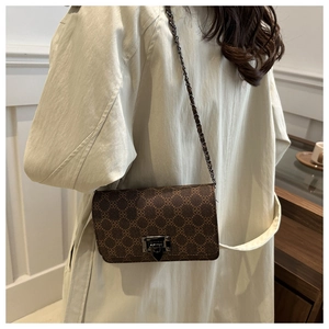 Detail of vintage square crossbody bag with clover pattern and metallic chain strap