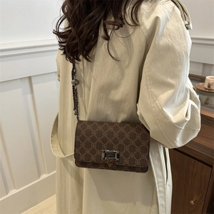 Retro geometric shoulder bag with chain strap and rivets shown on a beige trench coat