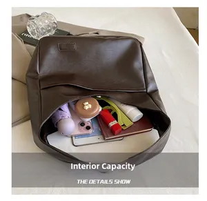 Internal capacity of large dark brown leather tote bag showing tablet and essentials