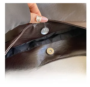 Detailed close-up of the vintage brown tote bag showing a high-quality magnetic snap closure