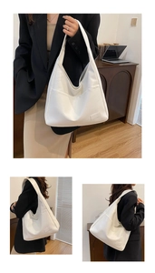 Detail view of large white faux leather tote bag with functional front pockets and U-shaped design