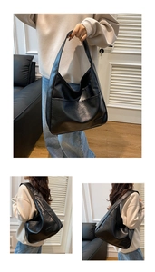 Close-up of black matte PU leather tote bag with wide strap and front pocket detail