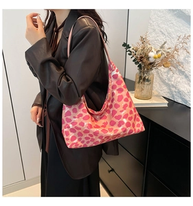 Borsa tote rosa con stampa leopardata e tracolla larga mostrata in un interno moderno