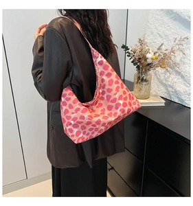 Vista dettagliata della borsa hobo leopardata arancione indossata da modella in ambiente moderno