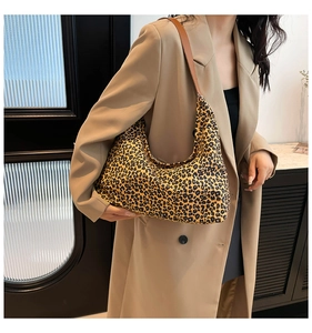 Dettaglio della borsa a mezzaluna leopardata con tracolla marrone sulla modella