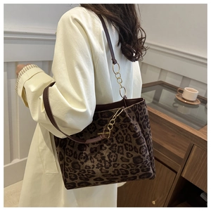 Detail of leopard print suede tote bag with chain strap and gold logo plate