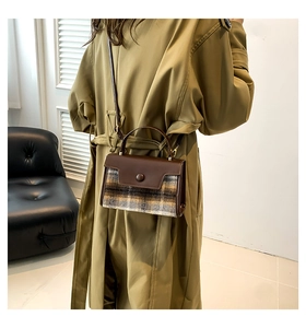 Detail view of the vintage plaid wool handbag styled with a long trench coat