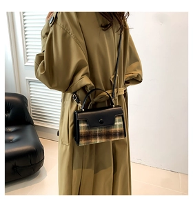 Close-up of a plaid flap handbag styled with a khaki trench coat for a retro look