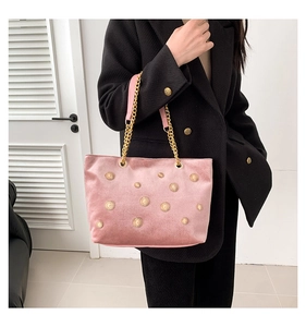 Gros plan du sac cabas en velours rose avec ornements soleil dorés et bandoulière chaîne