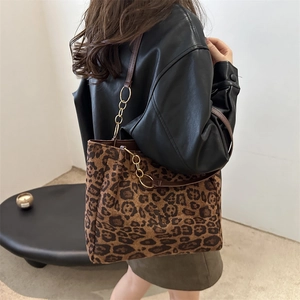 Large leopard print tote bag with brown leather straps and gold chain link details