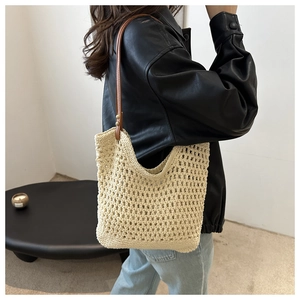 Detail showing the cotton crochet hollow mesh texture and brown leather strap of the tote bag