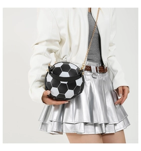 Detail view of the black and white soccer ball crossbody bag with a golden chain strap