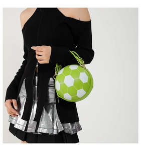Detailansicht einer kreativen Handtasche in Fußballform mit grünem Leder und Goldreißverschluss