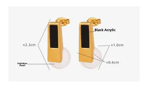 Detail view of gold geometric earrings with black acrylic inlay and white imitation pearl