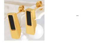 Detailed view of geometric golden earrings with black enamel inlay and white round pearl