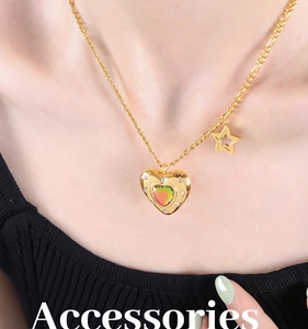 Dettaglio della collana a cuore dorata con pietra iridescente e stella sul collo