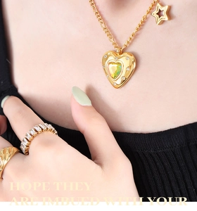 Dettaglio di una collana con pendente a cuore dorato, stella e anelli strutturati abbinati