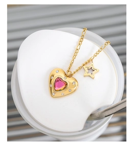 Dettaglio della collana dorata con cristallo rosa a cuore e ciondolo a stella