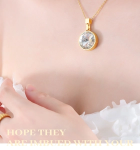 Close-up of a gold titanium steel necklace featuring a large round clear crystal stone