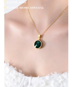 Detail of vintage gold necklace featuring a dark green round-cut glass gemstone pendant
