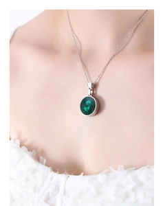 Detail of green multifaceted crystal pendant on a silver-tone chain necklace