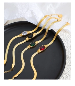 Detail of four gold snake chains with oval gemstones in white, black, green and red