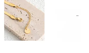 Detail of gold herringbone chain with lobster clasp and adjustable extension link