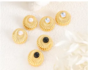 Detailed view of vintage gold stud earrings with textured finish and faux pearl inlays