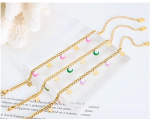Dettaglio di bracciali a stella e luna con ciondoli in smalto colorato in oro