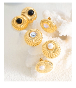 Detail of vintage gold earrings with shell texture featuring pearl and opal stones