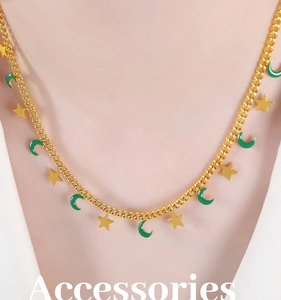 Dettaglio della collana dorata con stelle e lune in smalto verde indossata da modella
