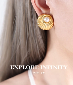 Detailed close-up of vintage gold earrings with imitation pearl and pleated metal texture