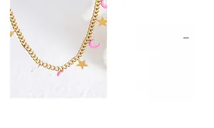Dettaglio della collana a catena dorata con luna in smalto rosa e ciondoli a stella