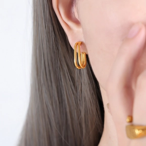Orecchini geometrici rettangolari doppi in oro 18K indossati da una modella elegante