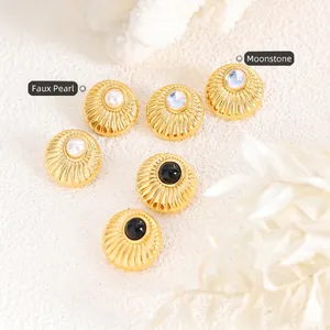 Vintage gold textured earrings with faux pearl and moonstone insets on a chic background