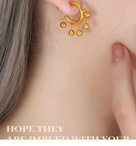 Détail de boucle d'oreille créole à franges en or 18 carats avec perles sur l'oreille