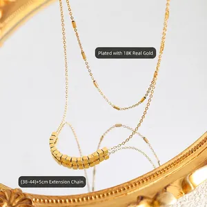 Collier double épaisseur élégant plaqué or 18K avec perles cubes sur une surface miroir