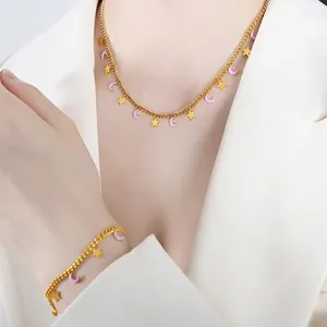 Set di gioielli con ciondoli a stella e luna in smalto rosa su una catena dorata