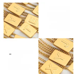Detail of 18K gold plated titanium steel rectangle pendants with embossed letters