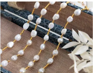 Macro detail of natural white baroque pearls and golden beads on a vintage wooden surface