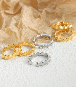 Dettaglio degli anelli aperti a onde con finiture lucide in oro e argento