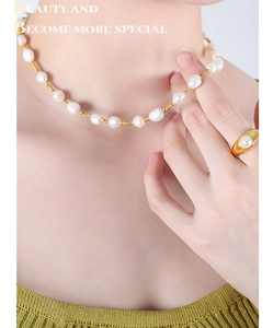 Detail of baroque freshwater pearl necklace and 18K gold plated ring set on model
