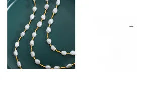 Close-up of baroque freshwater pearl necklace with gold bead accents on a green plate