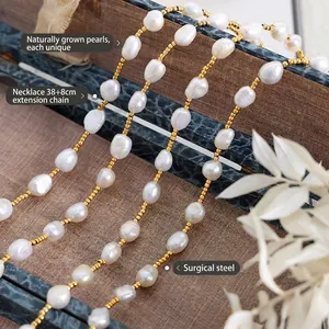 Titanium steel necklace featuring natural freshwater pearls and golden beads on wood