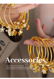 Macro view of woven gold steel bracelets with zircon charms like stars and hearts