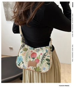 Close-up of floral tapestry canvas bag featuring a vintage pattern and brown leather patch