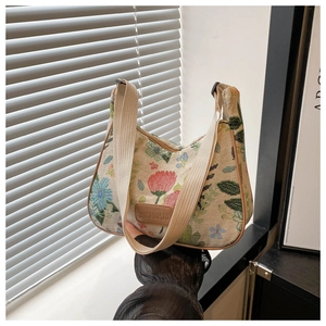 Close-up of floral jacquard hobo bag showing texture, canvas strap and leather logo