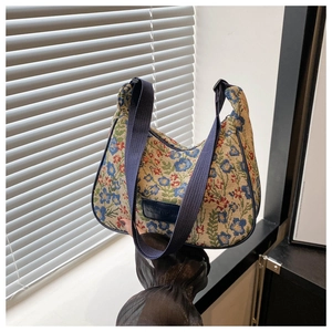 Macro detail of retro floral jacquard fabric and navy strap on the crescent hobo bag