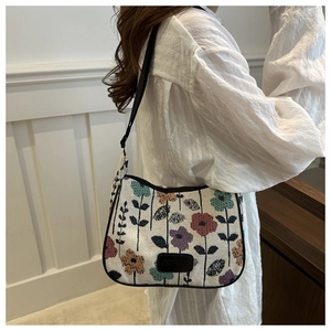 Detail of linen tote bag with colorful floral patterns and adjustable black strap