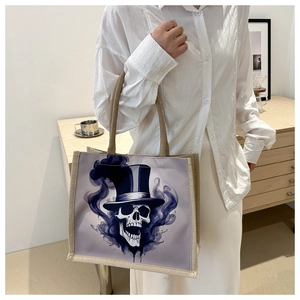 Detail of canvas tote bag featuring an artistic skull graphic with reinforced handles